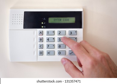 Security alarm keypad with person arming the system - Shutterstock ID 131357471