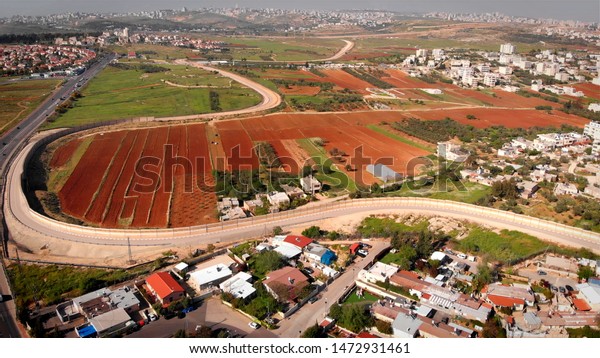Security\
Border wall aerial View\
Aerial footage of the Israeli Palestine\
wall close to Givon  and bir nabala\
town\
