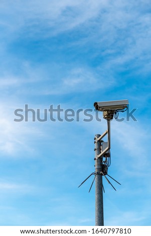 Security camera before blue sky