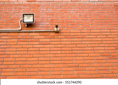 Security Camera And Led Flood Light At The Brick Wall