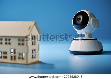 security camera and model house  on blue background.                  