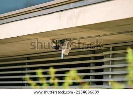 Security camera and motion detector placed on the facade of a building