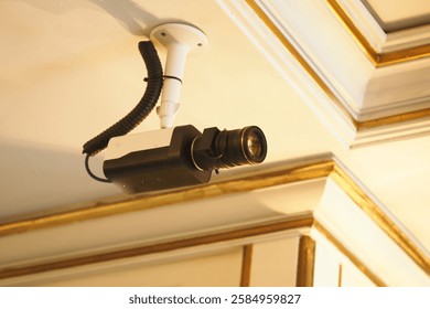 Security camera mounted on the ceiling in a well-lit room