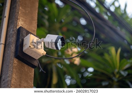 A security camera mounted outdoors captures the environment, showcasing technology for safety and surveillance in residential or urban areas.