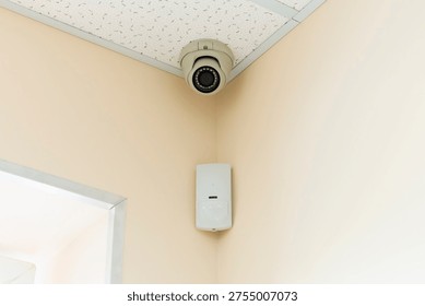 Security camera and speaker mounted in the corner of a room in a building