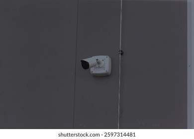 A security camera is strategically mounted on the side of a building to enhance surveillance and ensure safety around the property