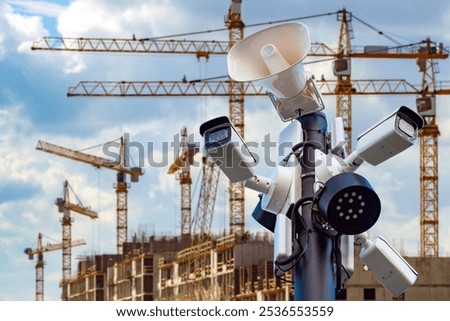 Security cameras on construction site. Pole with CCTV equipment. Megaphone near house under construction. Security cameras for protecting erection building. CCTV cameras for construction monitoring