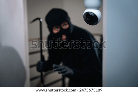Security camera.Thief in uniform black jacket various action housebreak. The Robber terrorism criminal escapes with balaclava and crowbar entering a house for stealing Housebreak at night