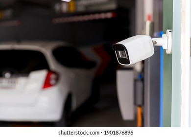 Security CCTV Camera Surveillance System Outdoor Of Carpark. A Blurred Night City Scape Background. Modern CCTV Camera On A Wall. Equipment System Service For Safety Life Or Asset.