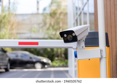 Security CCTV Camera Surveillance System Outdoor Of Carpark. A Blurred Night City Scape Background. Modern CCTV Camera On A Wall. Equipment System Service For Safety Life Or Asset.