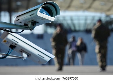 Security CCTV Camera Or Surveillance System With Military On Blurry Background