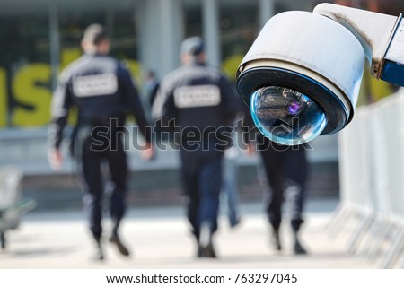 security CCTV camera or surveillance system with military on blurry background