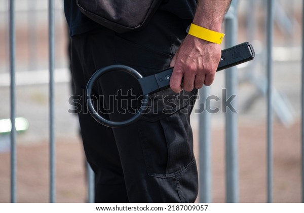 Security check metal detector device in hand\
of staff worker on check point of\
festival.
