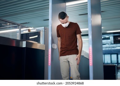 Security Checkpoint At Airport. Passengers Passing Through Gate Of Metal Detector.
