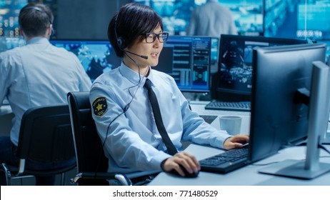 In The Security Command Center Officer At His Workstation Monitors Screens And Communicates With Patrols Through Headset. He Is Part Of The Surveillance Team.