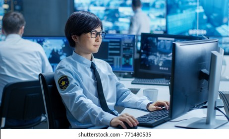 In The Security Command Center Officer At His Workstation Monitors Multiple Screens For Unlawful Infiltration. They're Guarding Important International Logistics Facility.