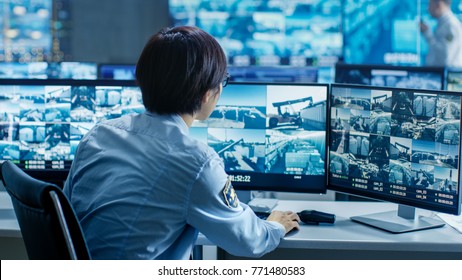 In The Security Control Room Officer Monitors Multiple Screens For Suspicious Activities. He's Surrounded By Monitors And Guards Facility Of National Importance.