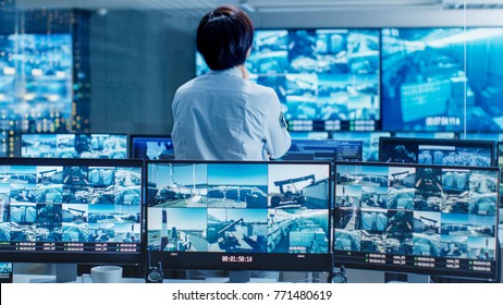 In the Security Control Room Officer Monitors Multiple Screens for Suspicious Activities. He Guards Internationally Important Logistics Facility.