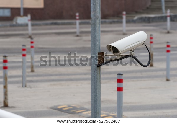 Security\
equipment concept - CCTV camera video surveillance on car parking\
at guard house safety system area\
control