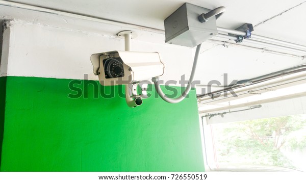 Security equipment concept. Closeup CCTV\
camera monitoring in the cars park. CCTV camera surveillance on car\
parking Safety system area control with copy\
space.