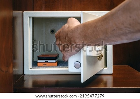 Security external hard drive in open metal safe. External hard disk containing confidential and important information keep well in white safe box. Confidentiality and Importance of Information Concept