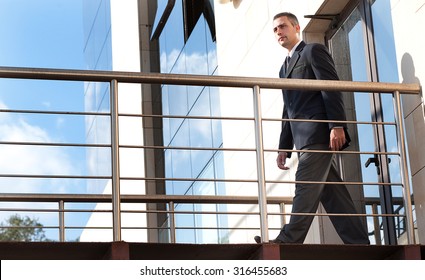 A Security Guard In Do His Patrol In  A Outdoor Corridor Of A Building