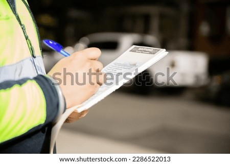 A security guard is giving a parking ticket to illegal parking on street of Toronto, Canada. Imagine de stoc © 