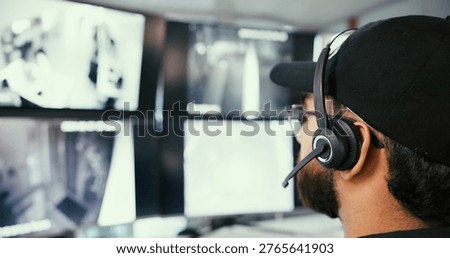 Security guard, man and computer in control room, headset for communication and video surveillance. Employee, officer or person in workplace, pc and monitor for building protection or listen to audio