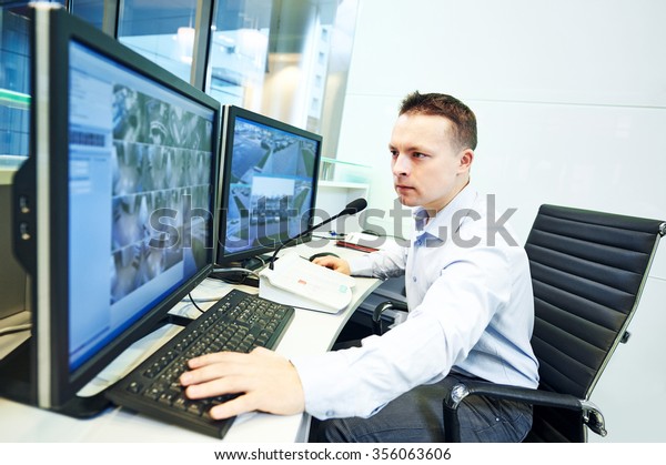 security guard officer watching video monitoring\
surveillance security\
system