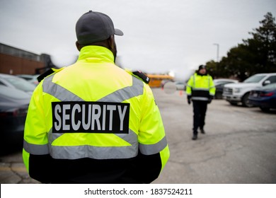 Security Guard Patrolling Around Parking Lot Area Under Cloudy Sky