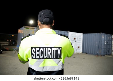 A security guard is patrolling a commercial storage area at night.
