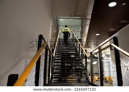 A security guard is patrolling an office at night.