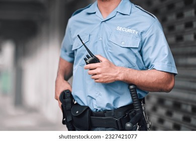Security guard, safety officer and man with walkie talkie in hand on street for protection, patrol or watch. Law enforcement, focus and duty with a crime prevention male worker in uniform in the city - Powered by Shutterstock
