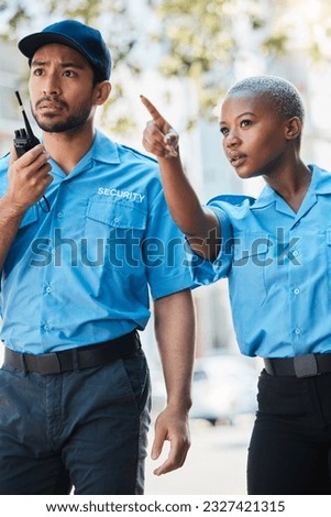 Security guard, safety officer and pointing on street for protection, patrol or watch for danger. Law enforcement, radio and serious crime prevention man and woman partner or team in uniform outdoor