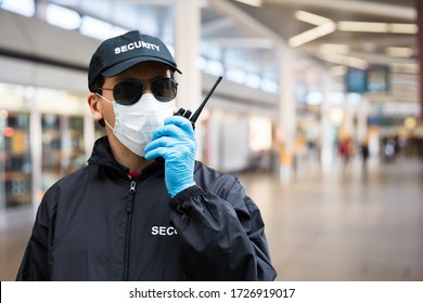 Security Guard Standing In Face Mask In Airport Terminal - Powered by Shutterstock