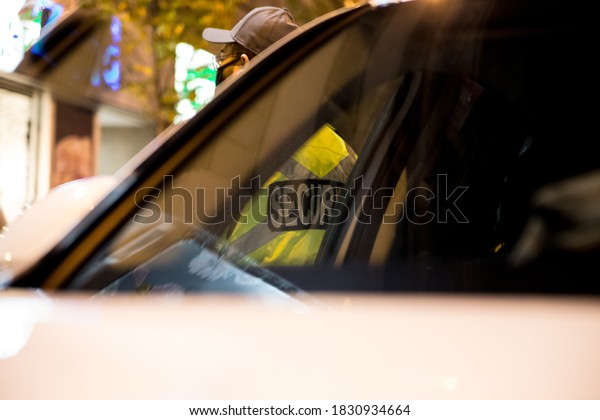 Security guard standing next to security car at
night city
