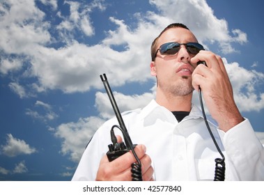 Security guard using hand-held radio for communication - Powered by Shutterstock