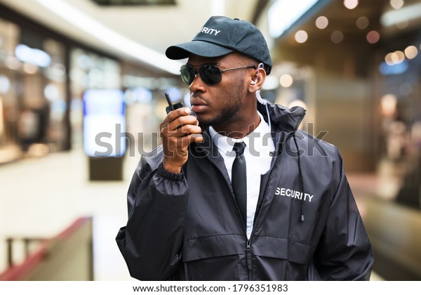 Security Guard\
Using Walkie Talkie In Shopping\
Mall