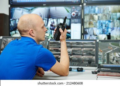 Security Guard Watching Video Monitoring Surveillance Security System With Portable Radio Transmitter