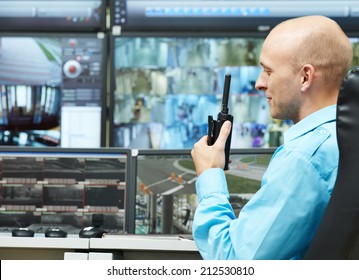 Security Guard Watching Video Monitoring Surveillance Security System With Portable Radio Transmitter