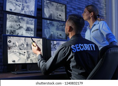 Security guards monitoring modern CCTV cameras indoors