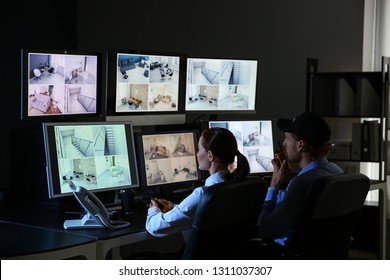 Security Guards Monitoring Modern CCTV Cameras In Surveillance Room