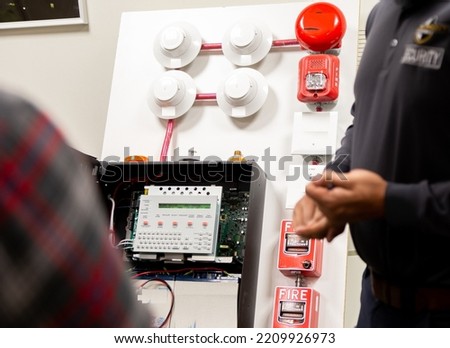 Security guards training how to use fire alarm and mock sprinkler system