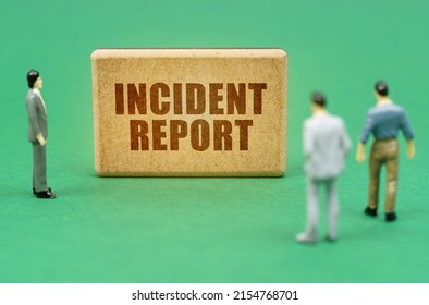 Security And Insurance Concept. On The Green Surface Are Figures Of People And A Sign With The Inscription - Incident Report