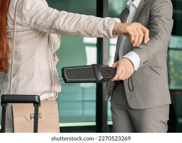 Security male officer using metal detector on female passenger at airport boarding gate. Airport travel and security concept. - Powered by Shutterstock