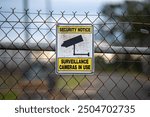 Security notice warning sign, surveillance camera cameras in use, chain link fence barrier, crime criminal break breaking in prevention, watch watching privacy private intrusive technology