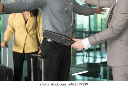 Security officer using metal detector on male passenger at airport boarding gate. Travel business airline and security concept - Powered by Shutterstock