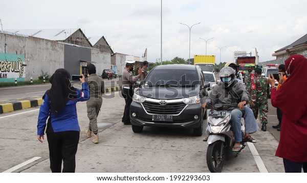 Security officers from the Indonesian National\
Police and Armed Forces intercept vehicles leaving the Toll Road,\
to be checked for transmission of Covid 19, Pekalongan, June 17,\
2021