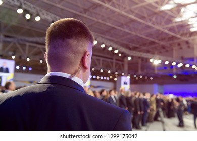 Security On Public Event. Secret Guard Service.  Private Bodyguard With Earpiece Standing Among Crowd. Safety Of Govern And Business Meeting. Secret Service Agent Listening To His Earpiece, Side.