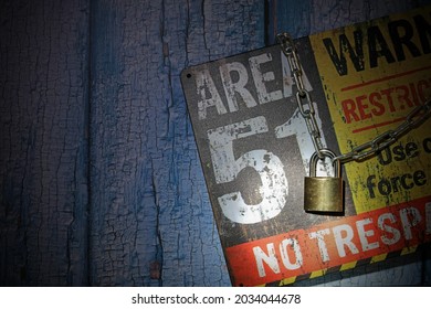 A Security Padlocked Chain Around An Area 51 Sign Lit By A Flash Light. Top Secret Concept.